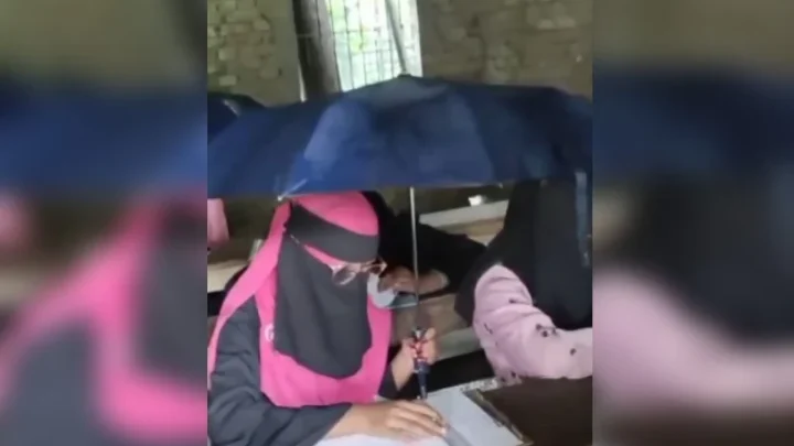 এক হাতে কলম অন্য হাতে ছাতা, বৃষ্টিতে পরীক্ষার হলে শিক্ষার্থীরা